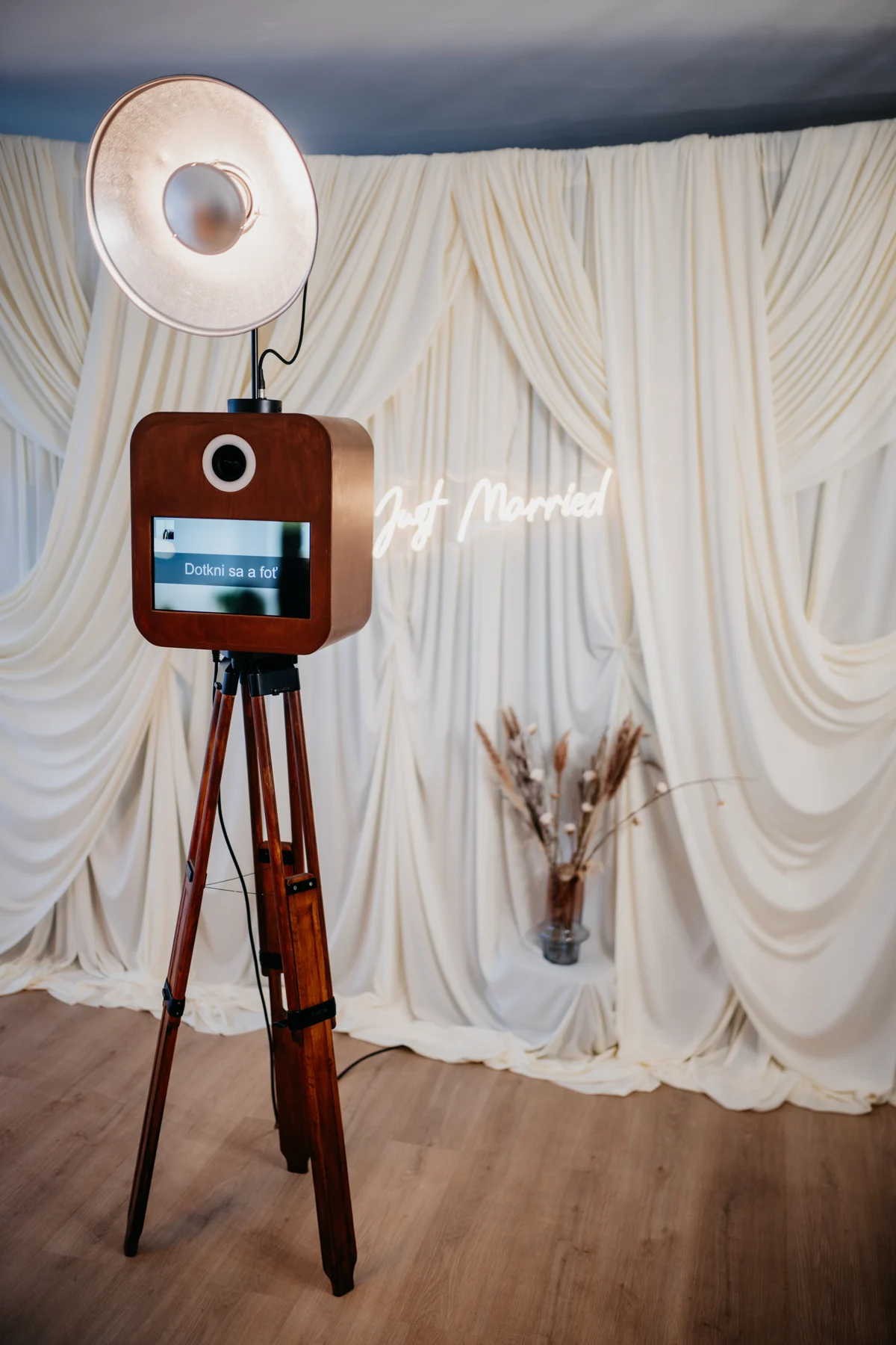 Drevený fotobox Maňko na statíve pred elegantným bielym fotopozadím