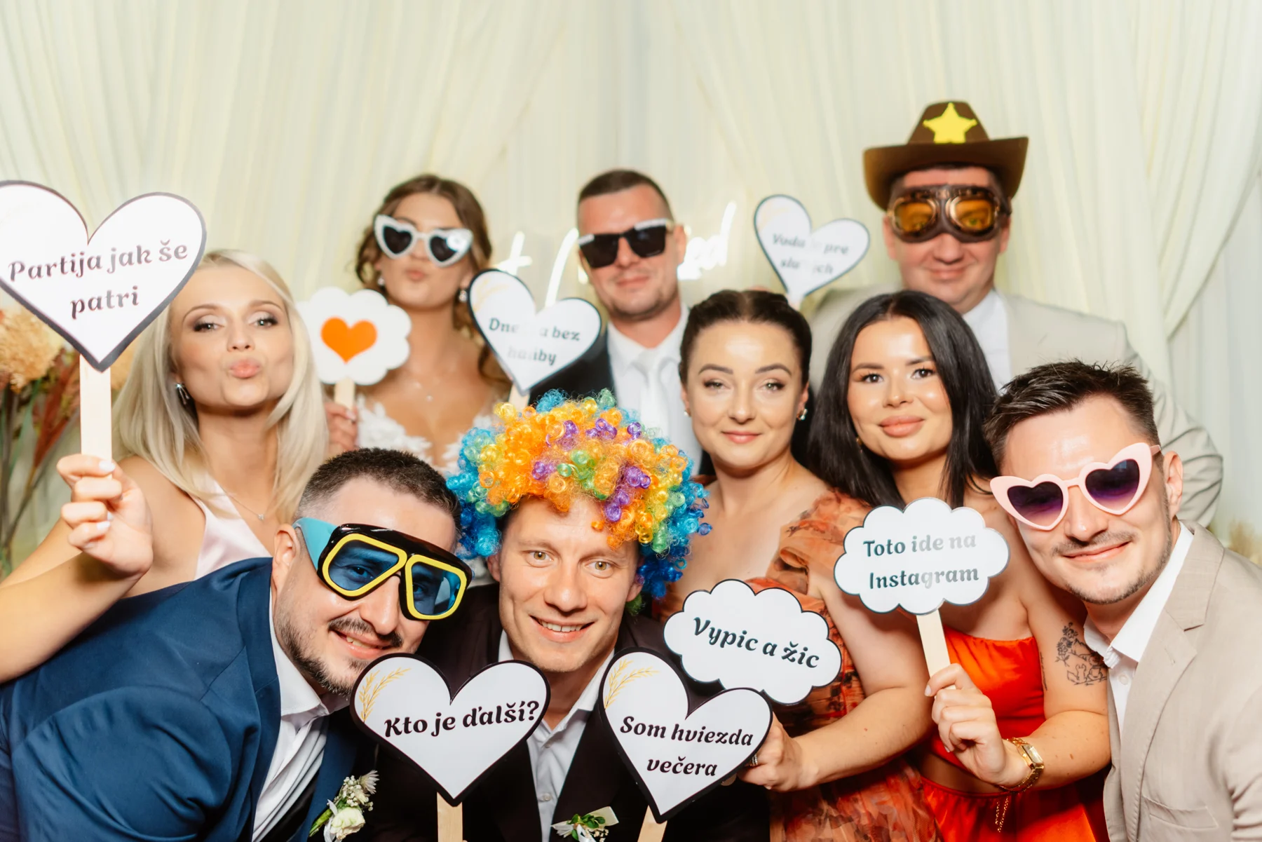 Veľká skupina svadobných hostí sa tlačí do spoločnej fotografie